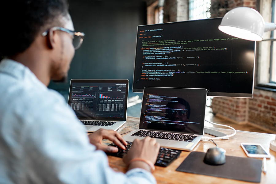 A cyber security expert monitoring three computers