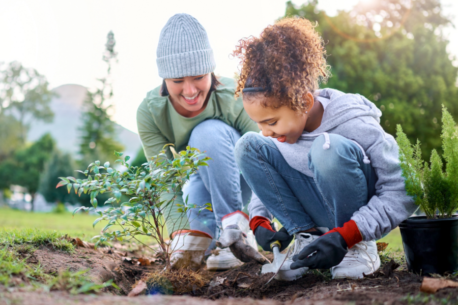 An adult and child having fun planting a tree