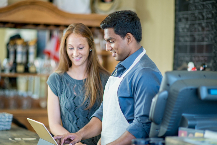 A manager training an employee at a point of sale