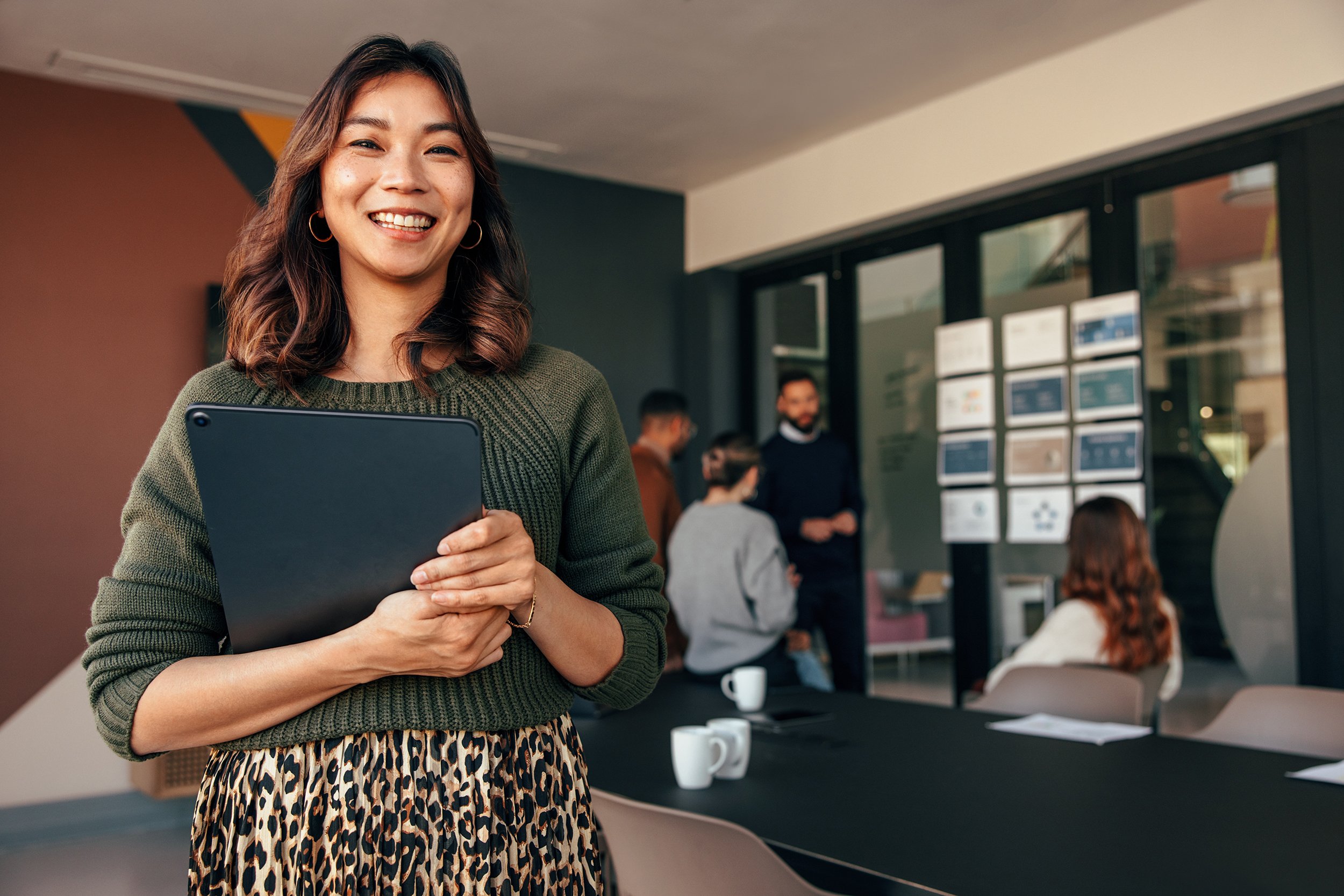 A smiling employee inside a meeting room