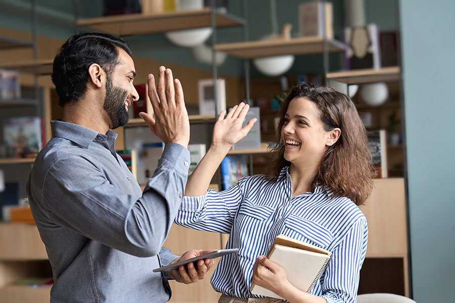 Two happy coworkers giving each other a high five