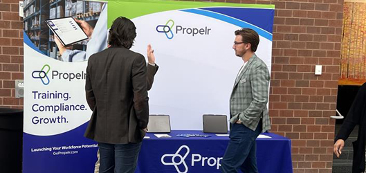 Two Propelr sales team members talking to a prospect at a learning and development conference